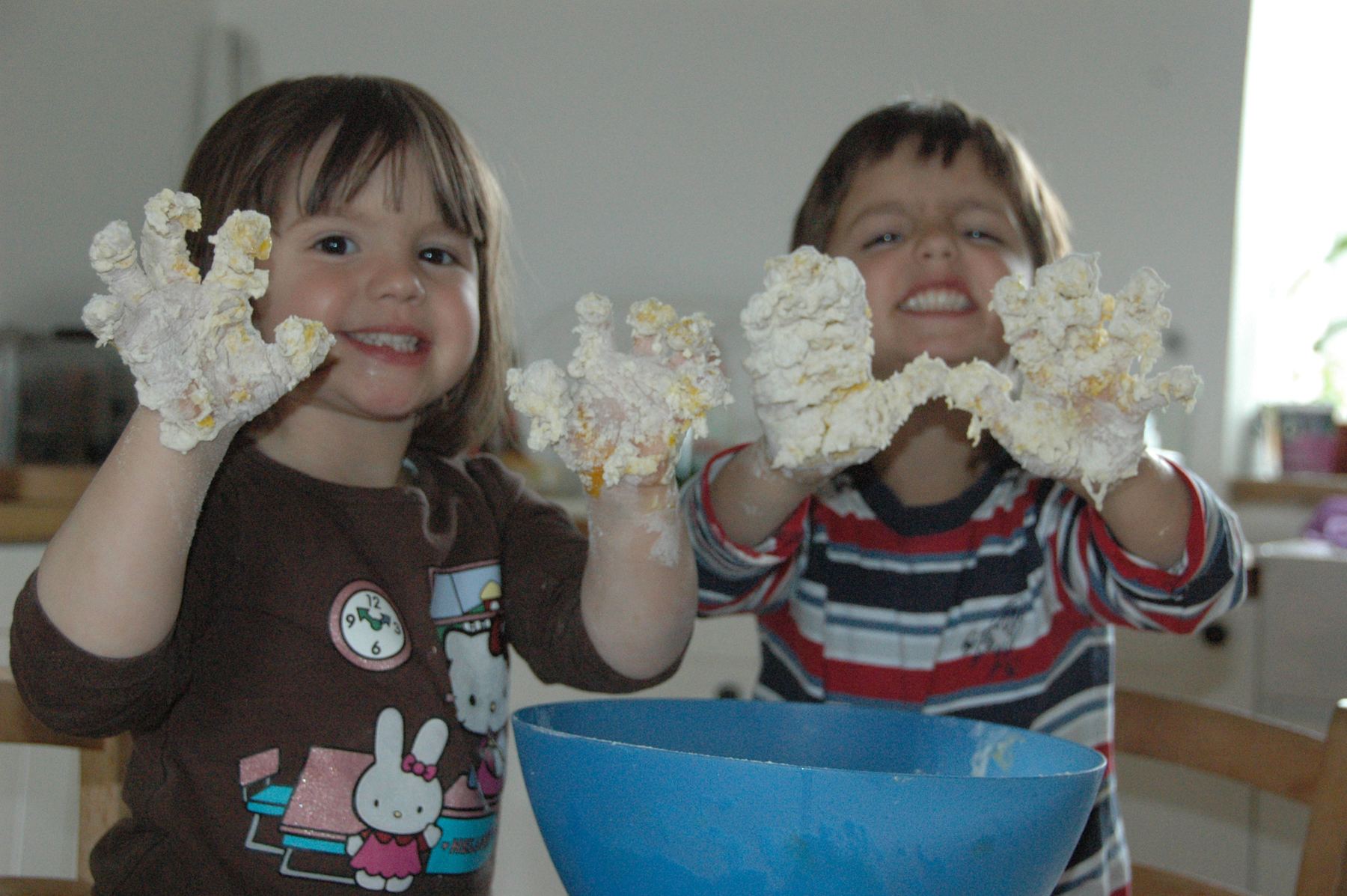 Two children with dough-covered hands