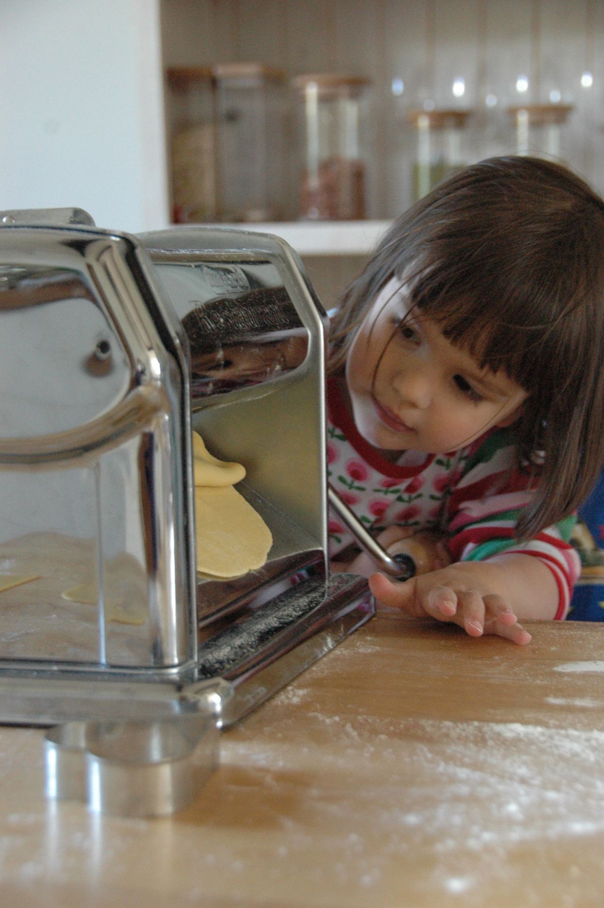 A child turning the pasta machine